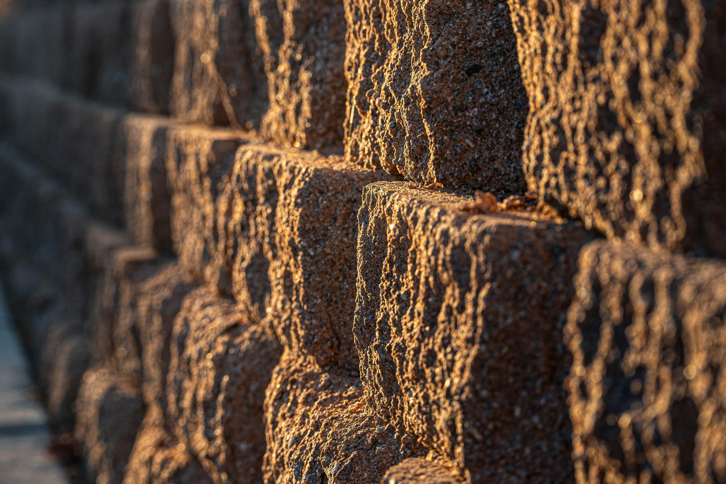 Close-up of a stacked concrete block retaining wall in low evening light