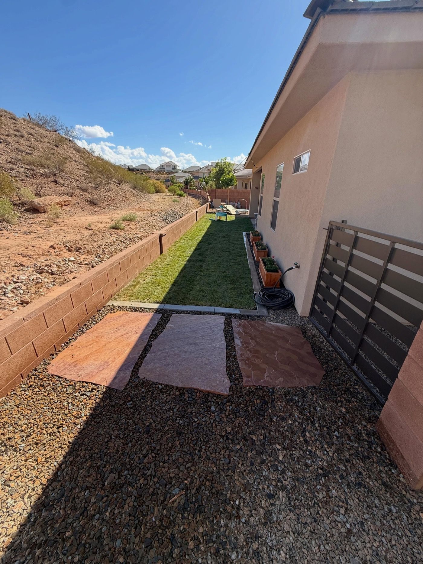 Red flagstone steppers set in rock mulch beside a strip of sod
